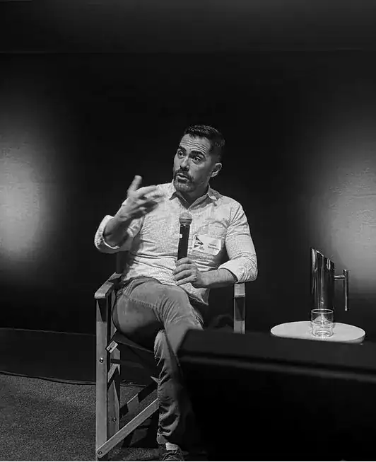 Vasileios Stavropoulos speaking on a panel, microphone in hand